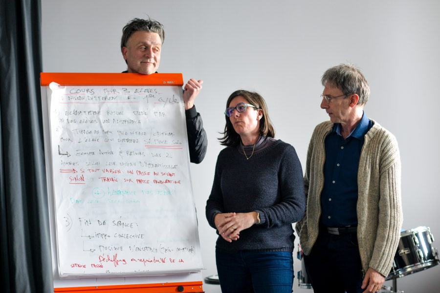 Trois personnes autour d'un tableau blanc